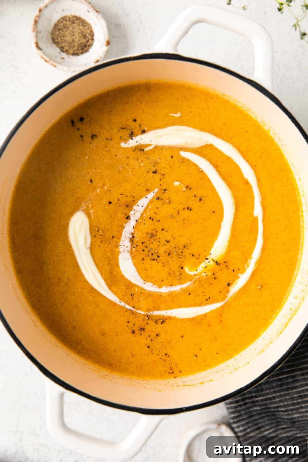 Creamy butternut squash soup simmering gently in a large, rustic pot on the stovetop, radiating warmth and inviting aromas.