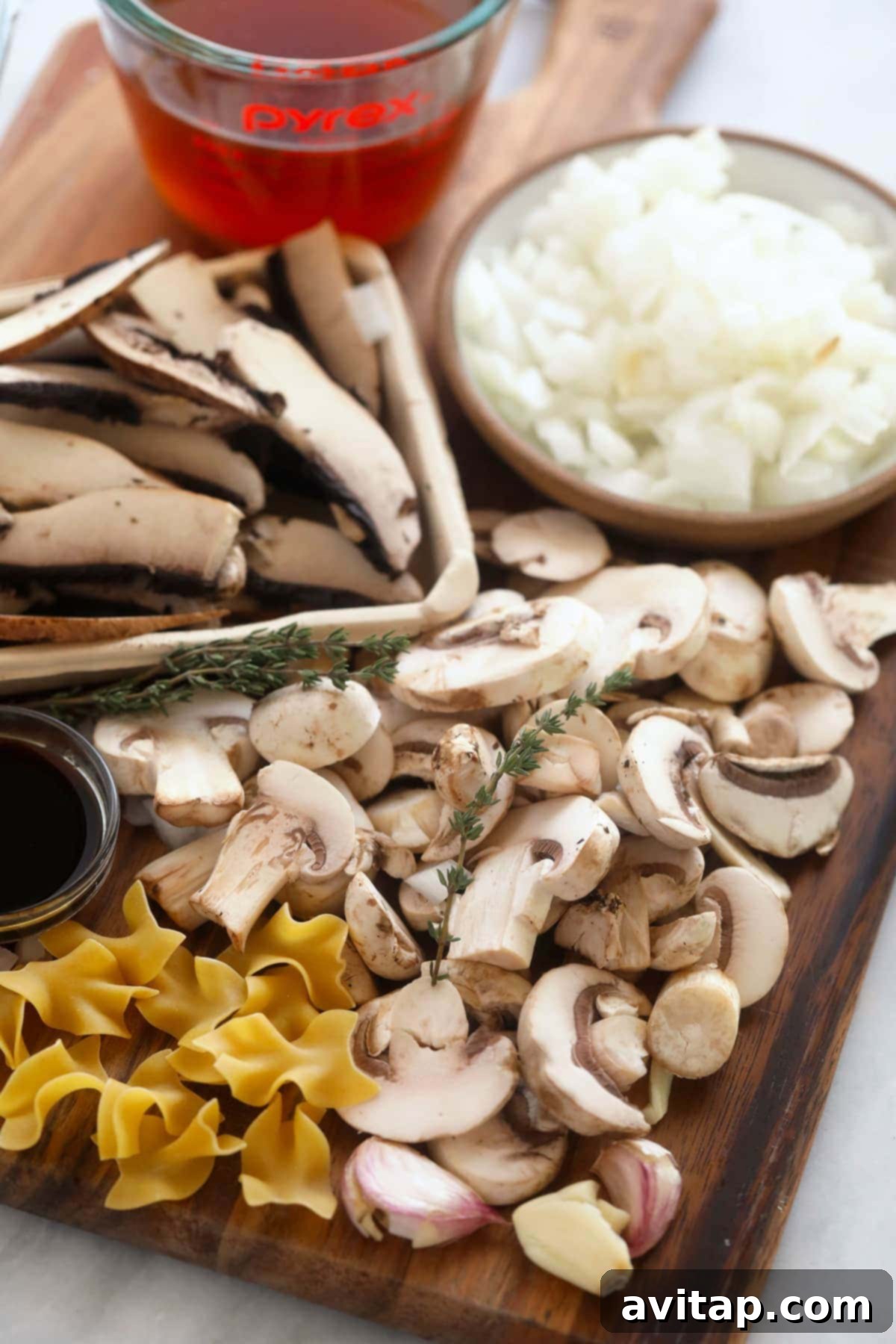 Velvet Mushroom Supper 4 Ingredients for healthy mushroom stroganoff laid out on a cutting board.