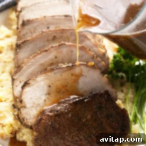 slow cooker pork loin sliced on a bed of mashed potatoes.