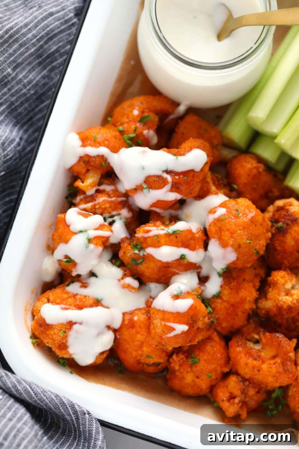 blue cheese sauce drizzled on buffalo cauliflower wings