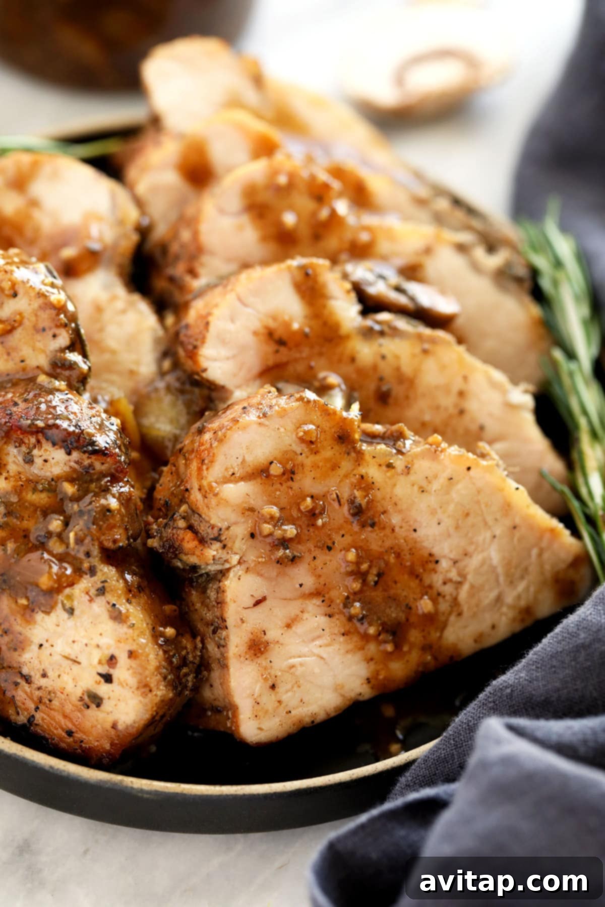 Sliced pork tenderloin on a white plate, ready to serve.