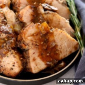Sliced pork tenderloin on a plate with gravy.