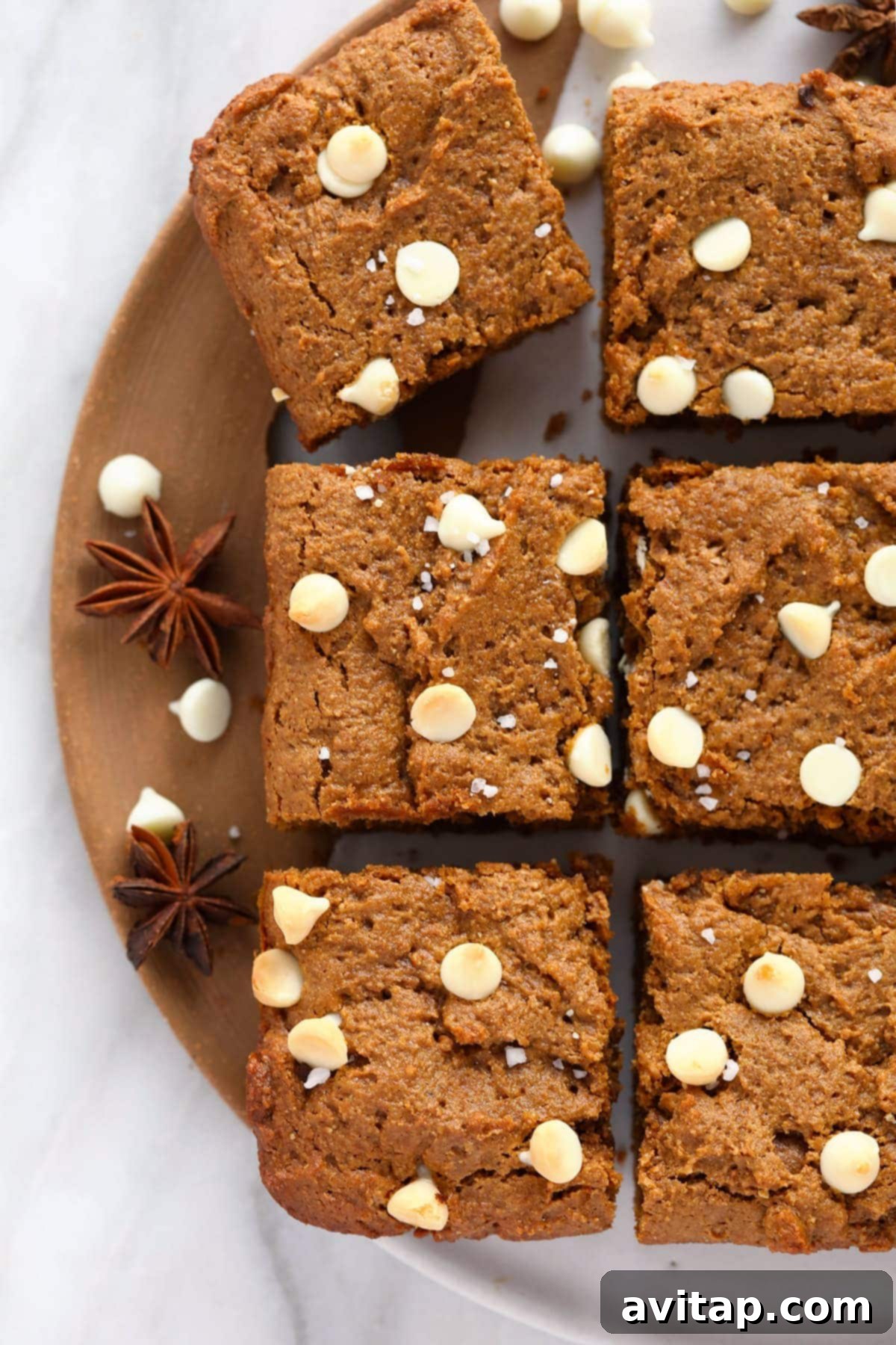 Delicious gingerbread cookie bars topped with white chocolate chips and a sprinkle of sea salt, ready to be enjoyed.