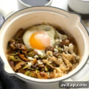 A vibrant bowl of savory oatmeal crowned with a golden-fried egg and fresh herbs, ready for a healthy and satisfying breakfast.