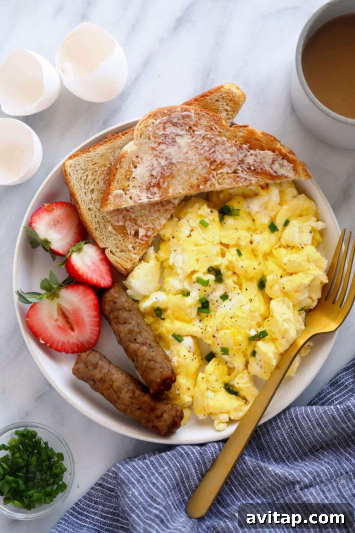 Fluffy Scrambled Eggs with Fruit and Toast A plate of perfectly fluffy scrambled eggs served with fresh fruit and golden-brown toast, highlighting a wholesome and inviting breakfast.
