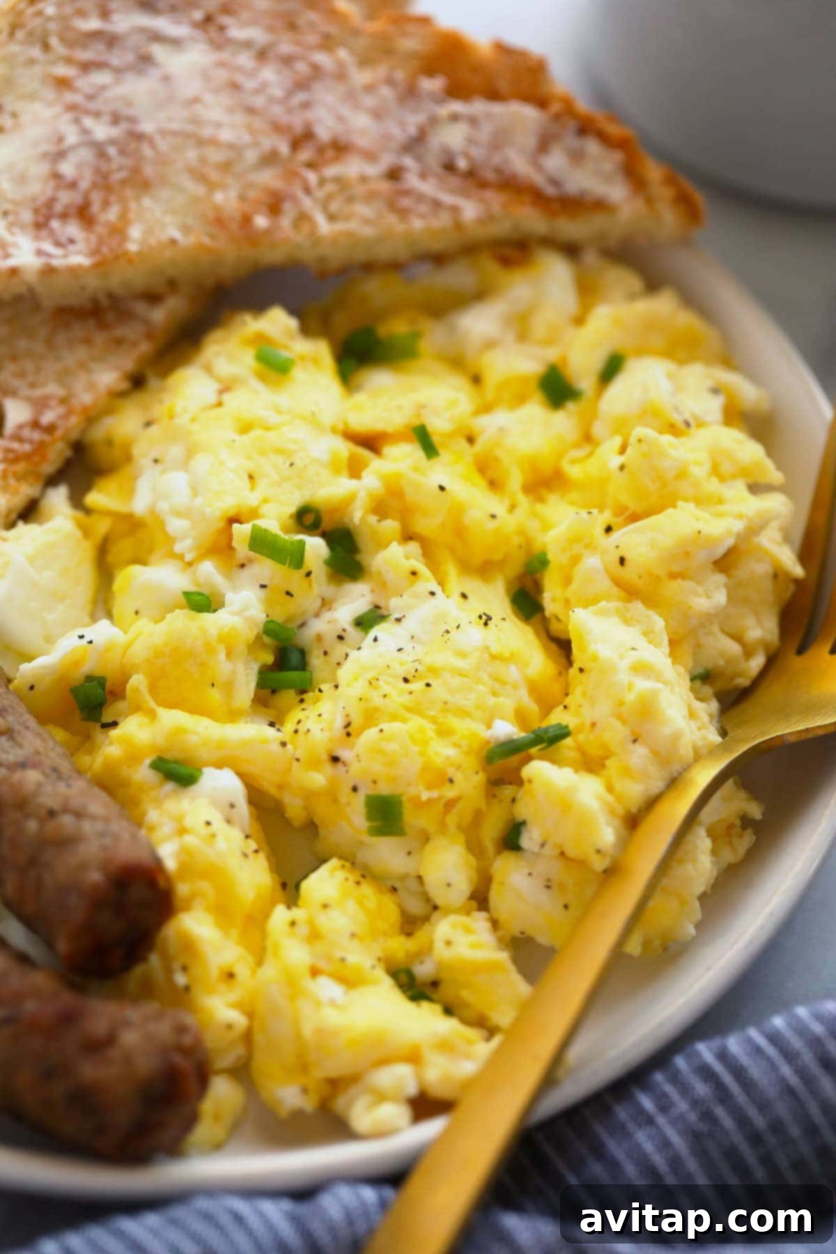 Breakfast Plate with Scrambled Eggs A delightful breakfast spread featuring perfect scrambled eggs alongside crispy toast and savory sausage links, plated beautifully.