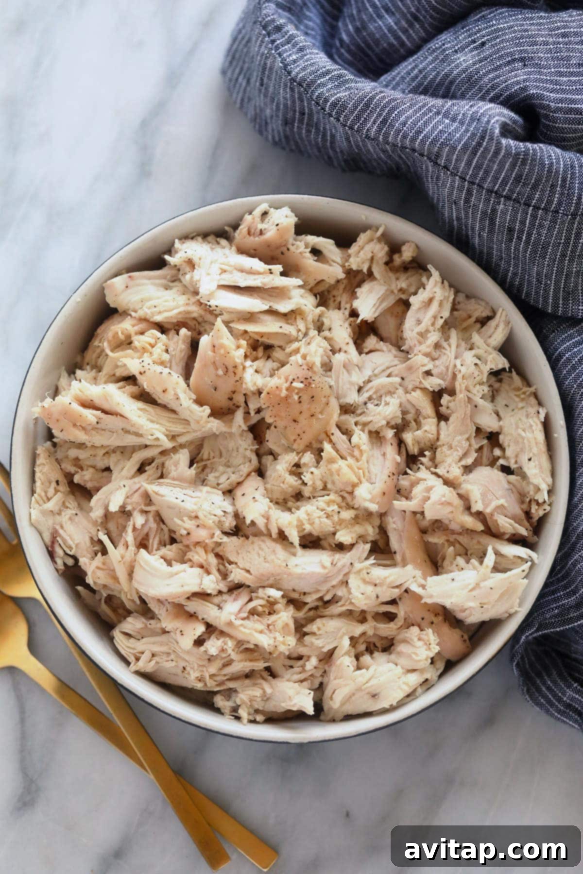A bowl filled with perfectly baked and shredded chicken, ready for meal prep or immediate use in delicious recipes.