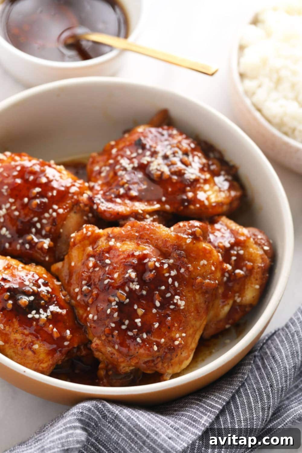 Oven-Fried Crispy Thighs 11 Tender Instant Pot chicken thighs served in a bowl, garnished with sesame seeds and fresh scallions.