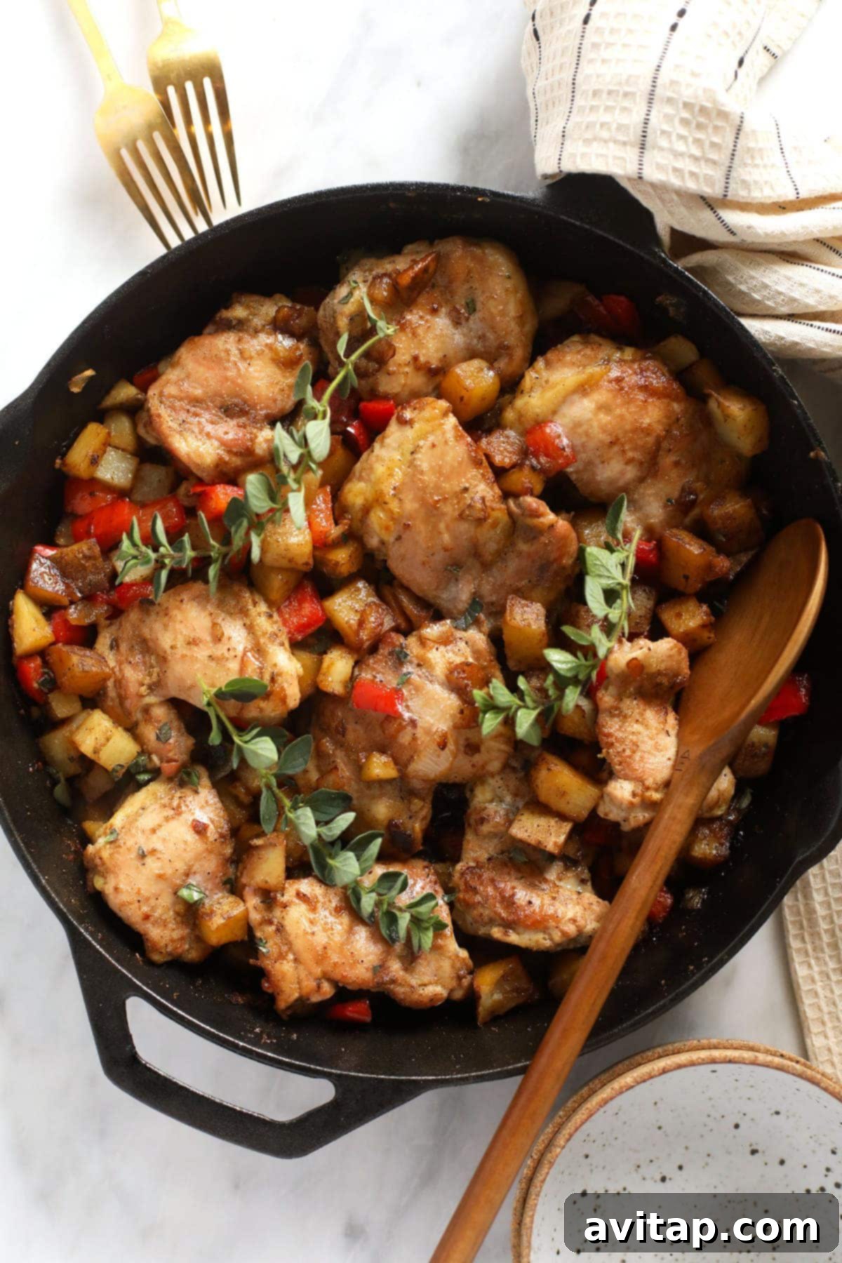 Oven-Fried Crispy Thighs 13 A cast iron skillet filled with golden-brown skillet chicken and potatoes, fresh from the oven.