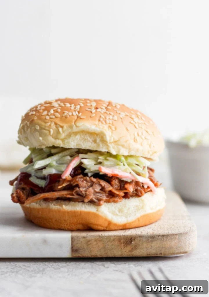 A mouth-watering pulled pork sandwich on a cutting board, ready to be enjoyed.