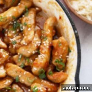 Sticky Honey Pork in a bowl with green onions and sesame seeds, a perfect pork recipe.