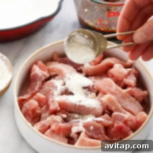 Pork strips coated in cornstarch, ready for cooking.
