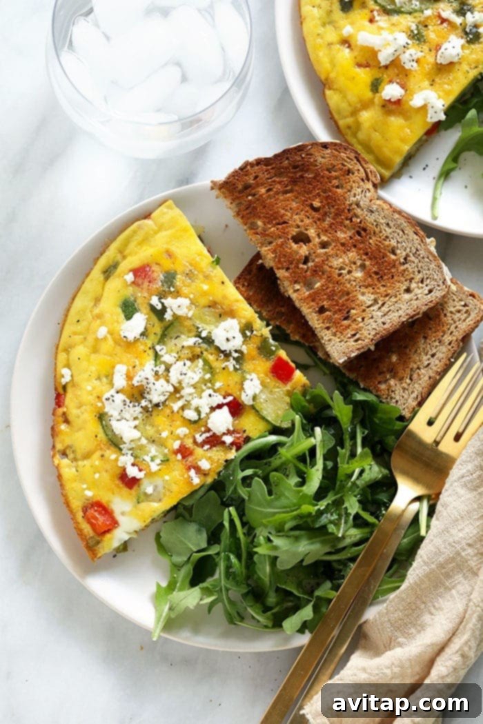 A beautifully plated slice of frittata, accompanied by a piece of crunchy toast and a fresh arugula salad, perfect for a balanced breakfast.