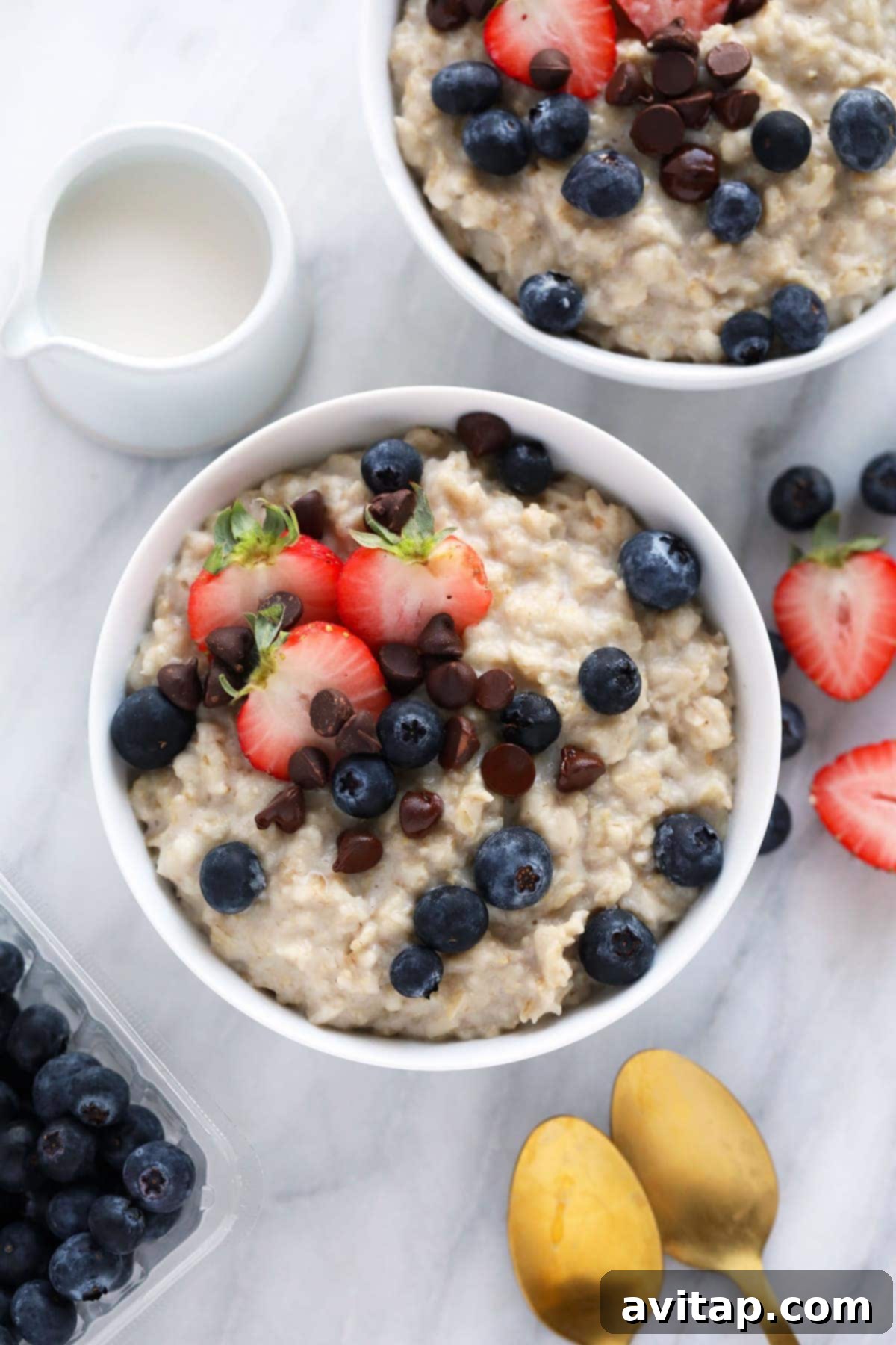 Easy Instant Pot Oatmeal made with old fashioned oats instead of steel cut made in less than half the time! Two cozy bowls of creamy Instant Pot oatmeal, garnished with fresh berries and nuts, ready for a healthy breakfast.