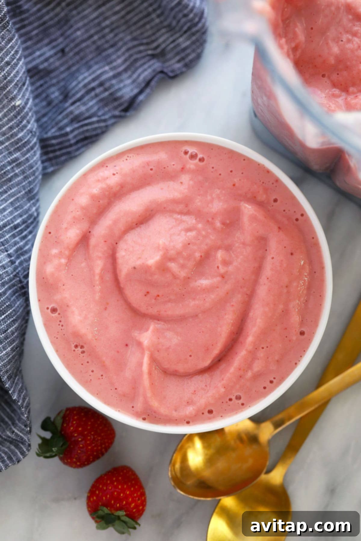 A vibrant strawberry smoothie poured into a bowl, beautifully thick and ready for a medley of nutritious toppings.