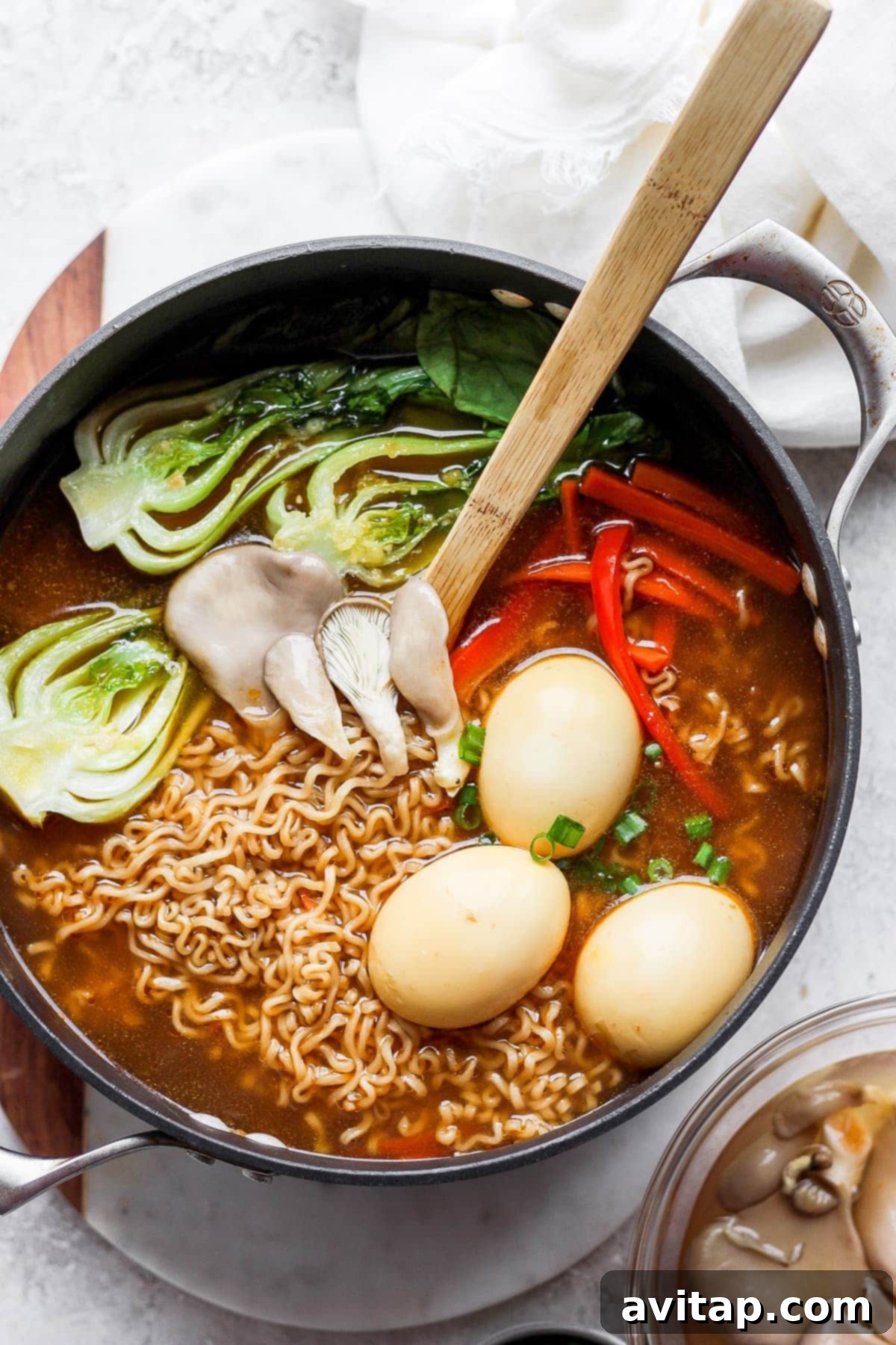 A large pot filled with rich, simmering ramen broth and noodles, ready to be served.