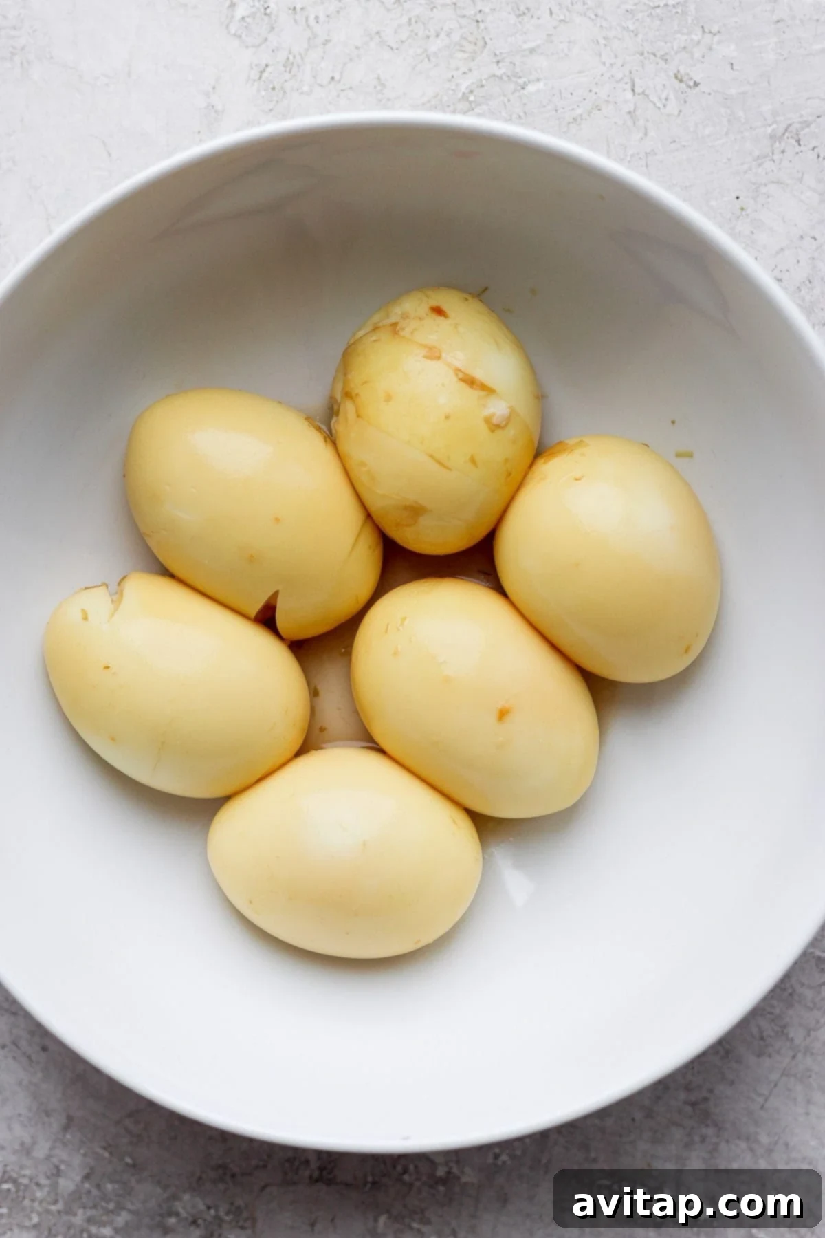 Beautifully marinated black tea ramen eggs, sliced in half to show their creamy yolks, presented on a minimalist plate.