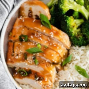 A vibrant, close-up shot of cooked teriyaki chicken breast, glistening with savory sauce