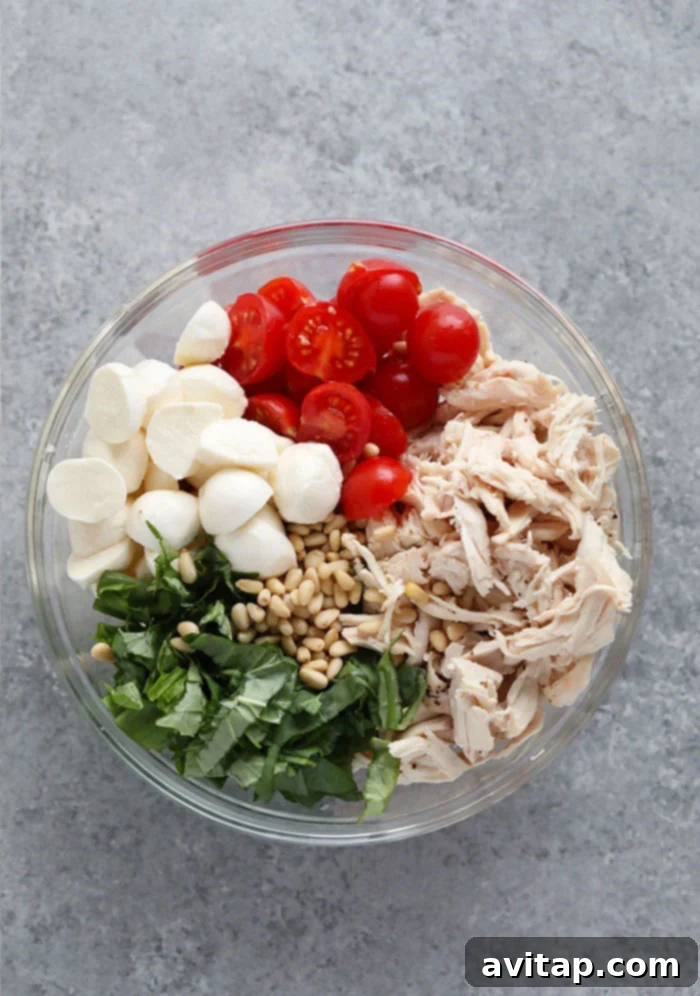 Fresh ingredients for pesto chicken salad in a bowl, highlighting a healthy and protein-packed meal.