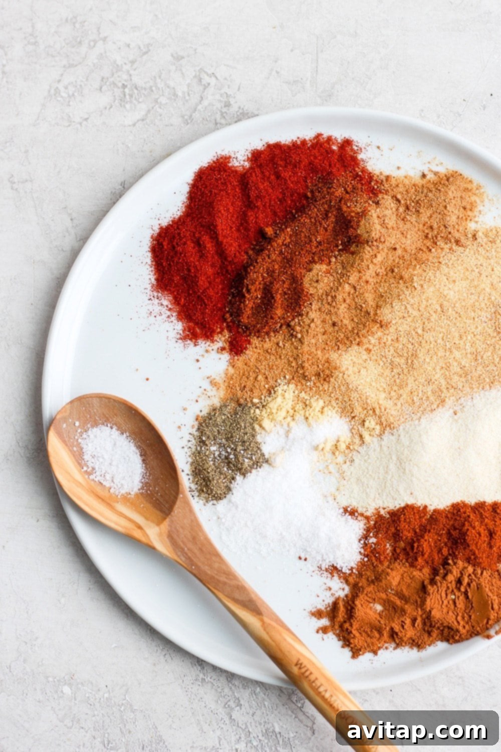 Carefully measured dry rub ingredients laid out on a plate, ready to be blended