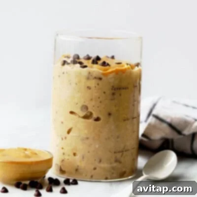 A charming glass jar filled with luscious peanut butter cookie dough overnight oats, clearly showcasing its creamy texture and delicious layers, ready to be enjoyed as a wholesome breakfast.