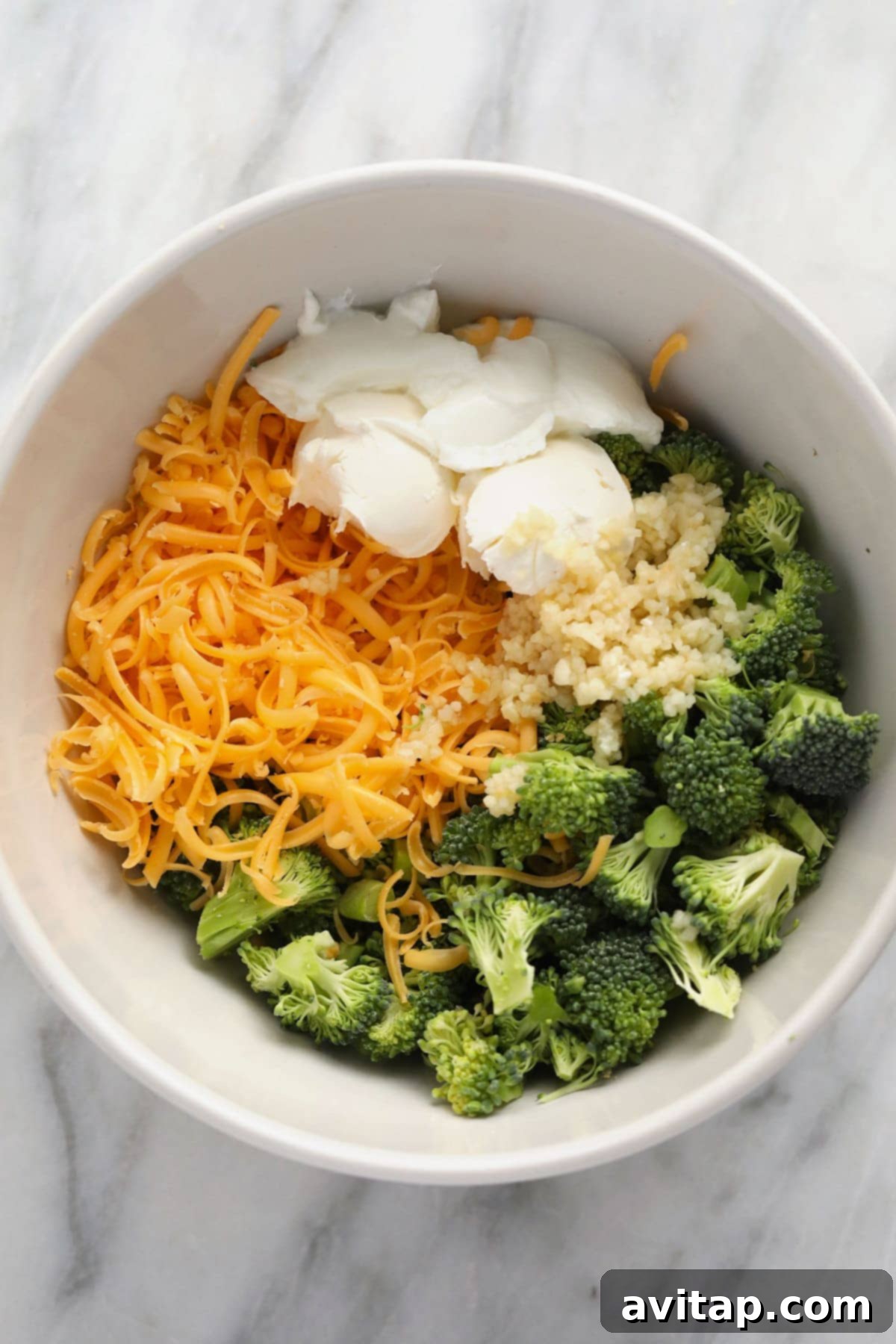 Creamy broccoli and cheese filling in a white bowl.