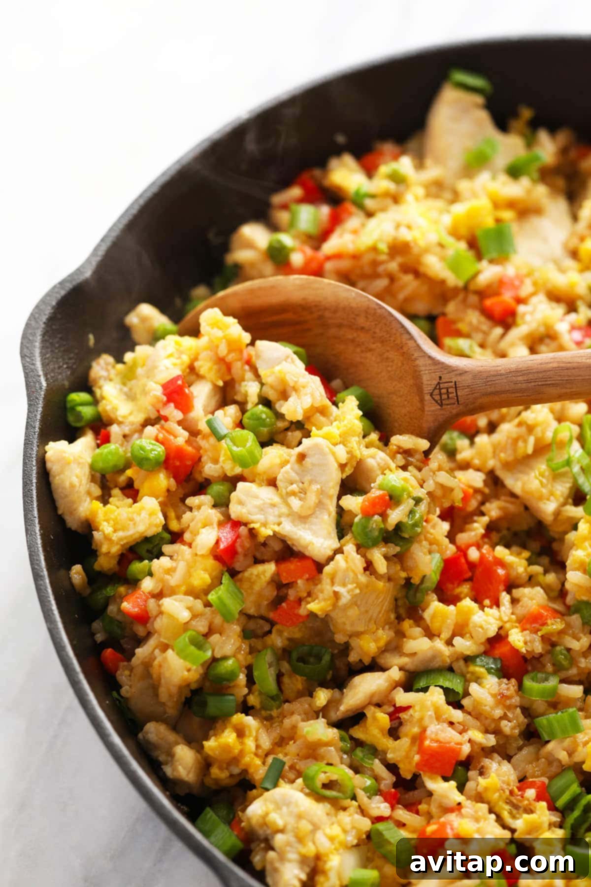 Freshly cooked chicken fried rice simmering in a large frying pan, ready to be served