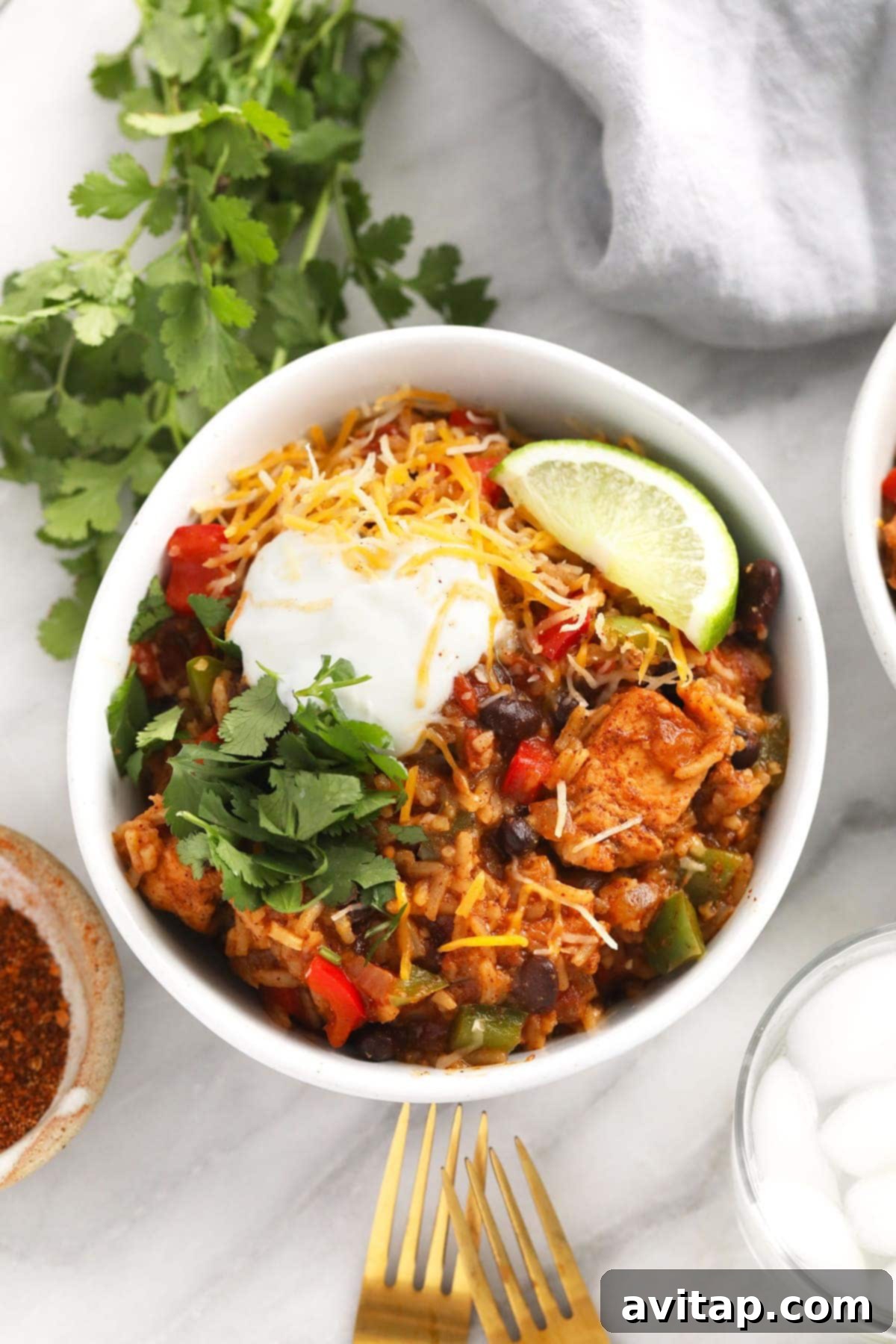 Quick Instant Pot Burrito Bowls 2 Instant Pot Burrito Bowl topped with shredded cheese, creamy Greek yogurt, and fresh cilantro sprigs