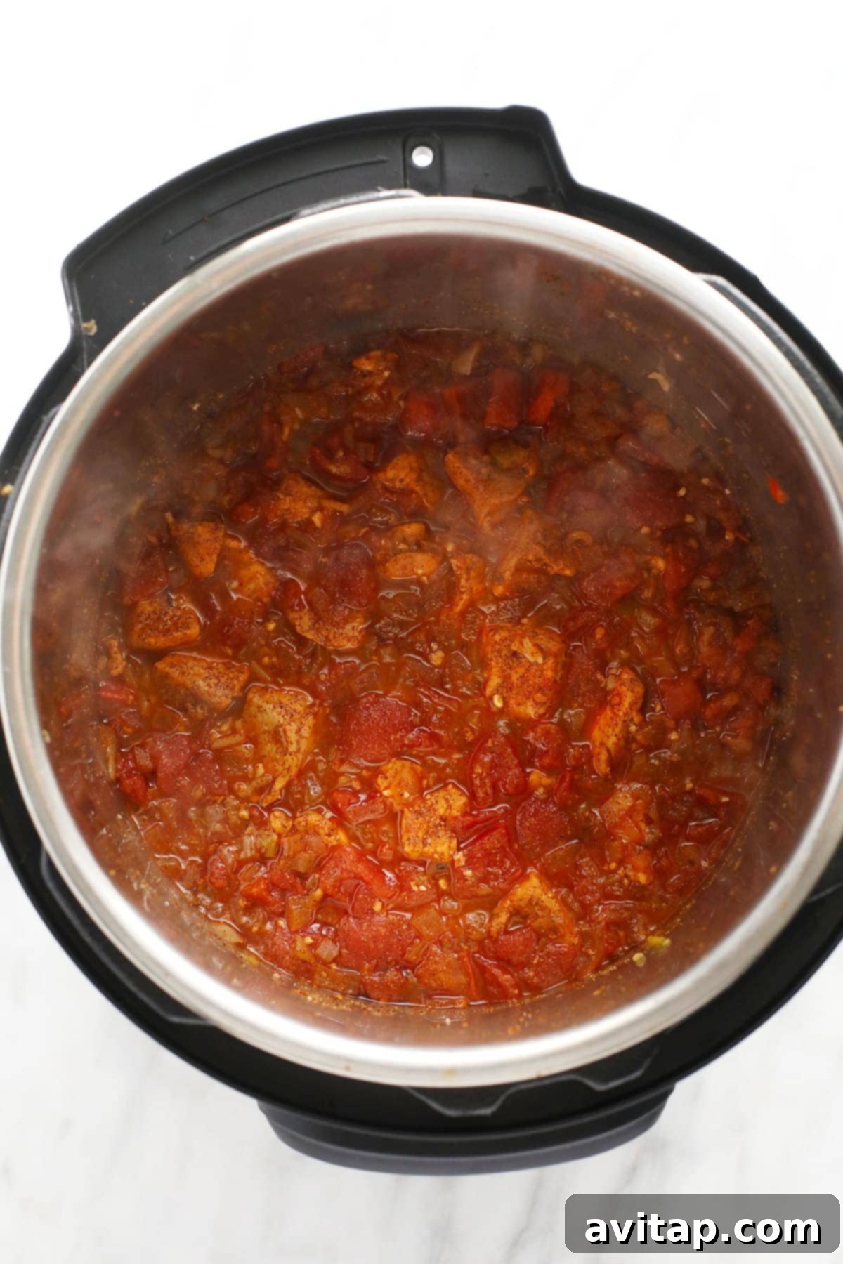 Quick Instant Pot Burrito Bowls 5 Sautéed chicken and diced tomatoes simmering with rice and spices in the Instant Pot, prior to pressure cooking for Burrito Bowls