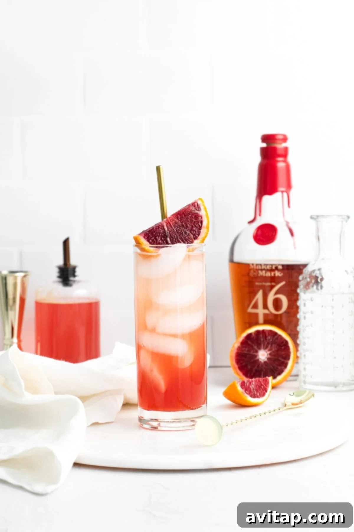 Sanguine Sunset Sip 9 A refreshing Blood Orange Smash served in a highball glass on a wooden surface.
