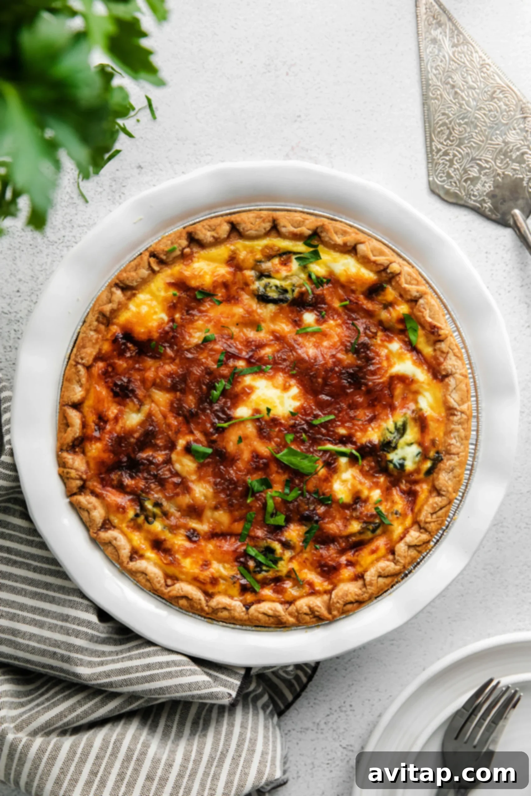 A perfectly baked spinach quiche with a golden crust and a light sprinkle of fresh parsley on top, showcased beautifully.