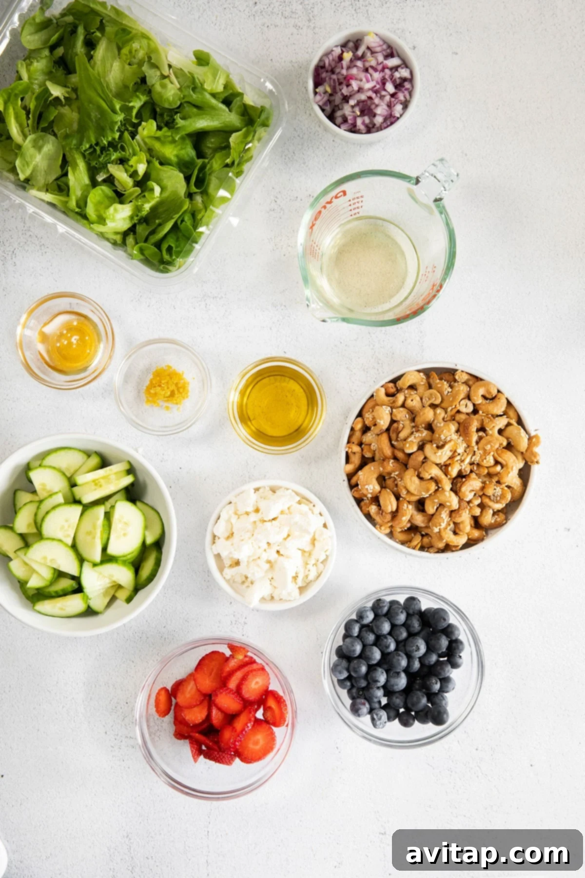 All of the individual ingredients for a spring mix salad neatly arranged in small bowls, ready for assembly.