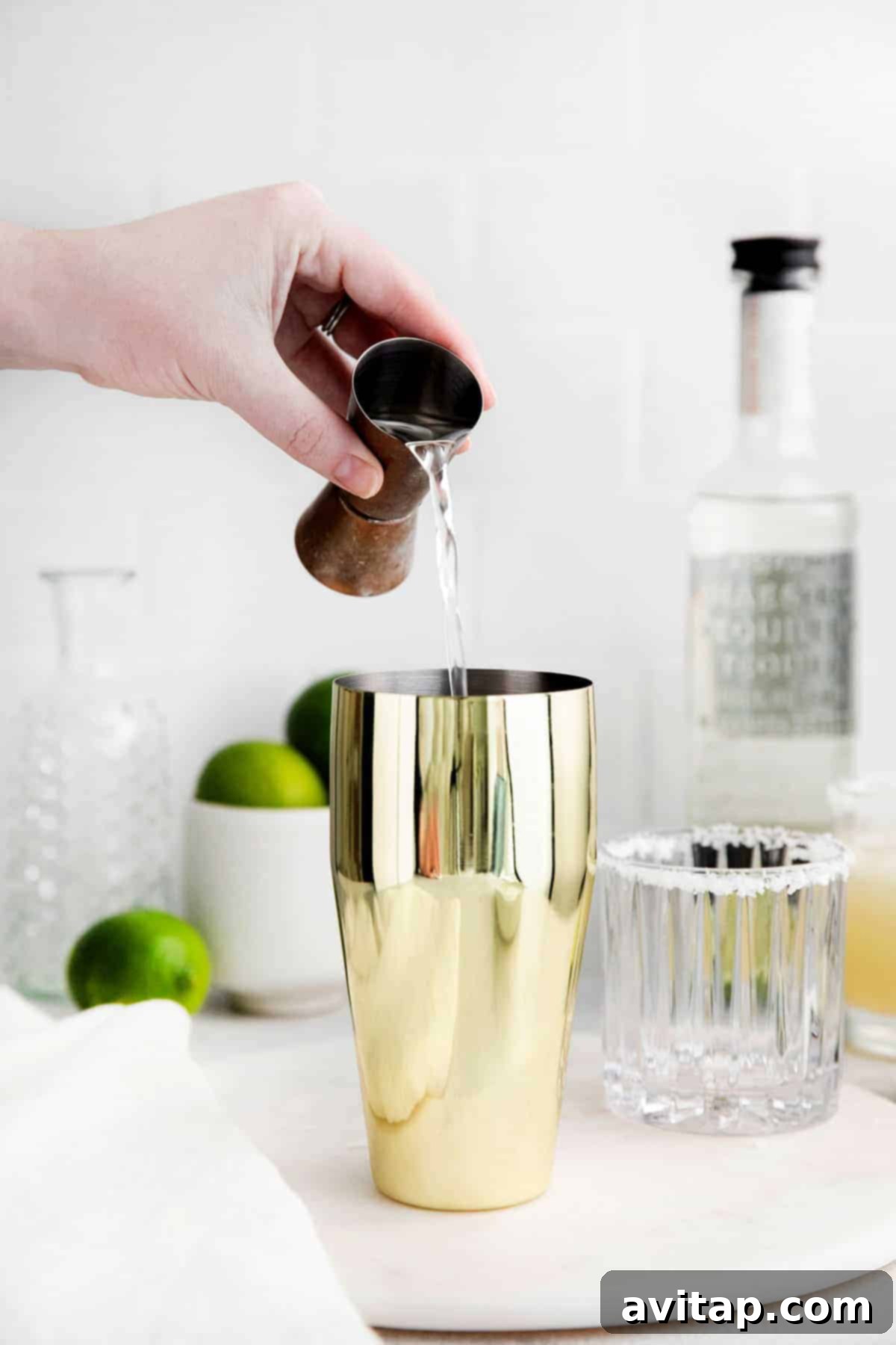 The Perfect Margarita 5 Tequila being poured into a cocktail shaker.