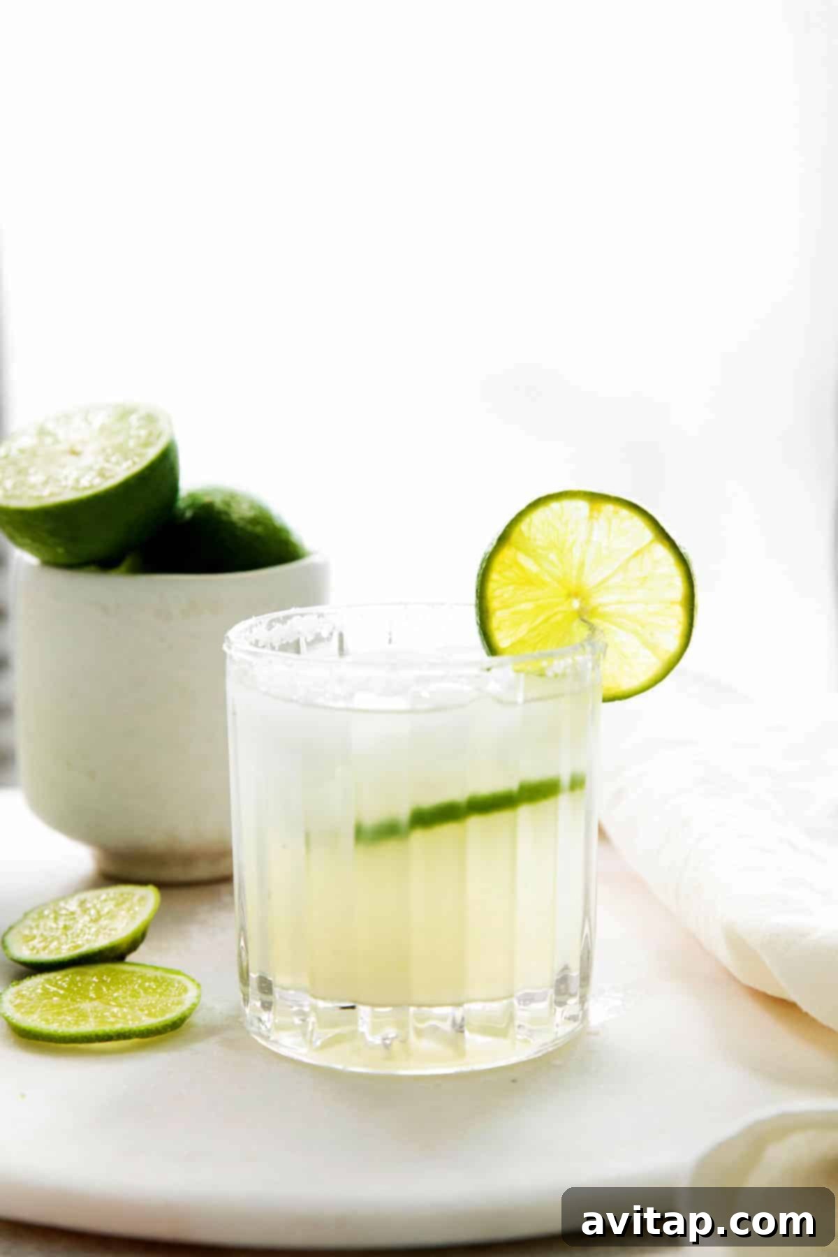 The Perfect Margarita 9 A cocktail glass full of margarita with a fresh lime slice.
