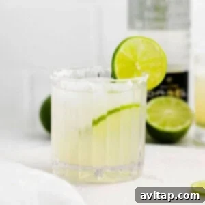 Classic margarita in a glass with a lime wedge garnish on a rustic countertop