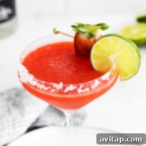 strawberry margarita with lime garnish and salted rim, viewed from above