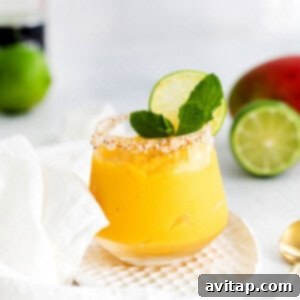 A freshly poured mango margarita in a glass, ready for garnish, with a focus on its inviting color and smooth texture.