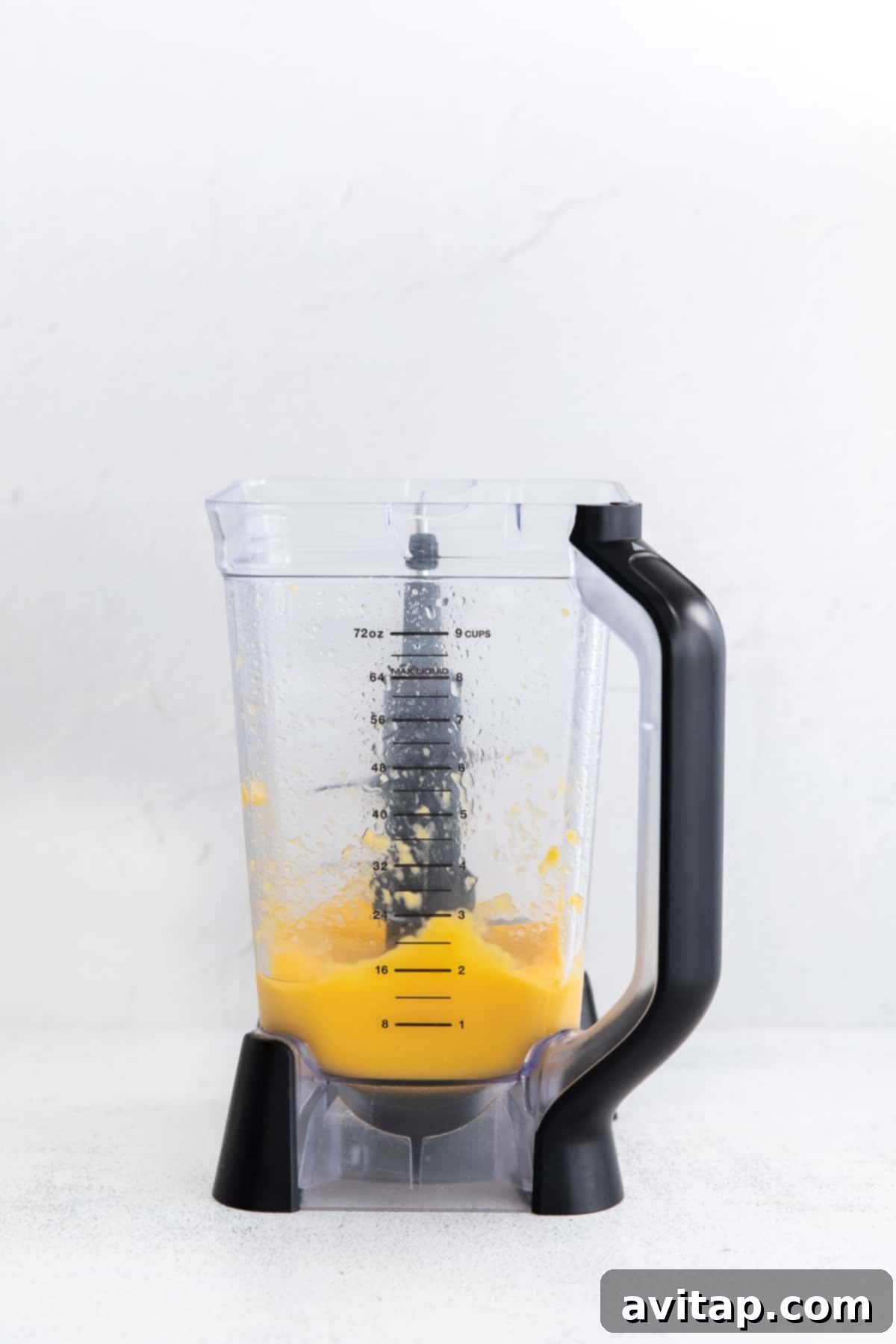 Sun-Drenched Mango Margarita 5 Smooth, beautifully blended frozen mango margarita swirling vigorously in a high-speed blender, creating a perfect frosty texture.
