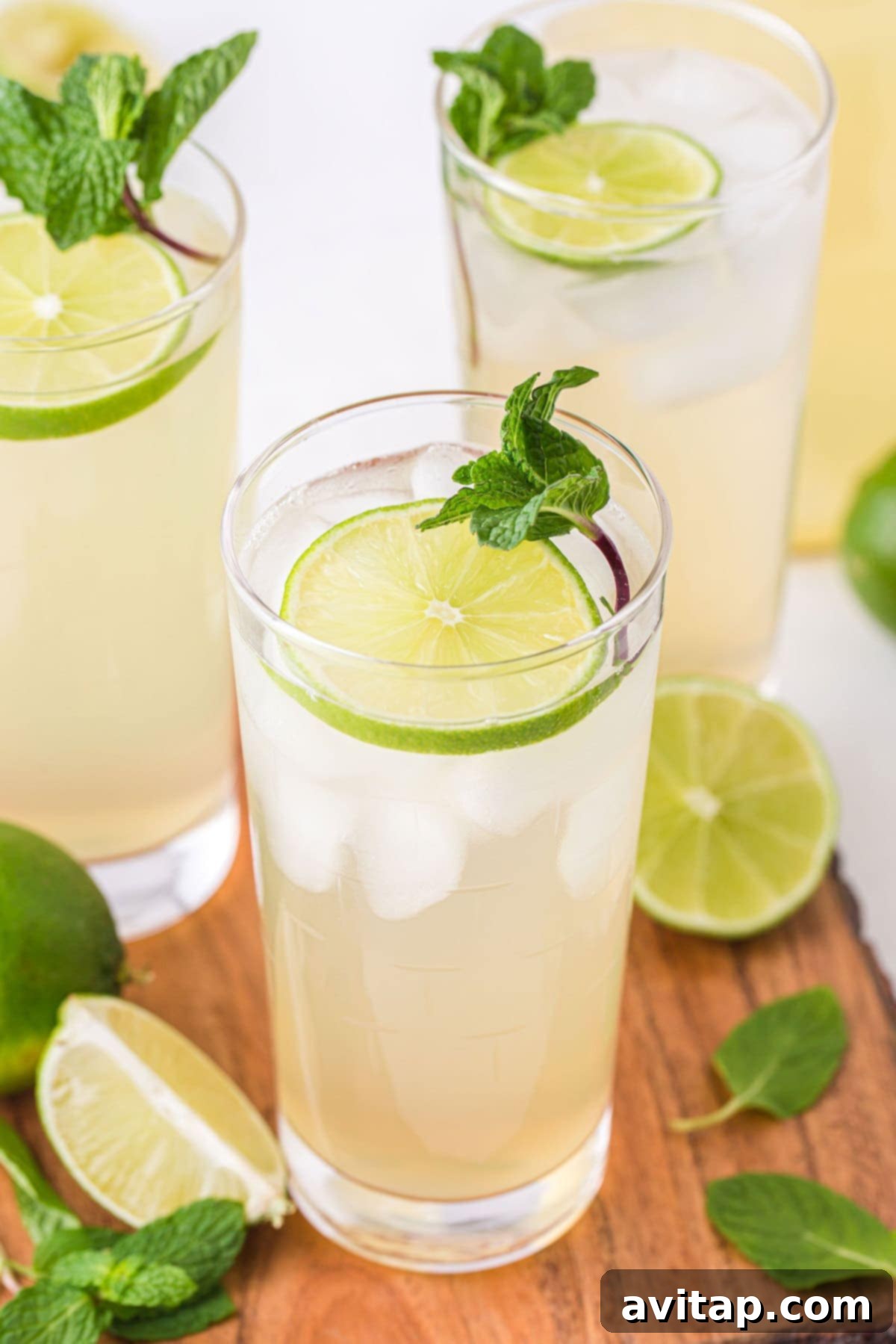 A vibrant glass of homemade limeade garnished with fresh lime slices and mint, showcasing its refreshing appeal and coolness.