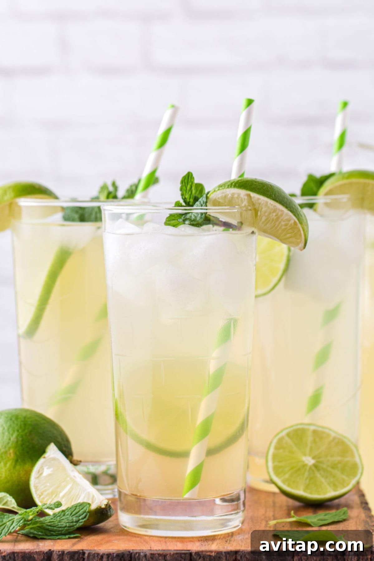 A beautifully presented glass of homemade limeade, garnished with a fresh lime slice and vibrant mint, resting on a rustic wooden surface, ready to be enjoyed.
