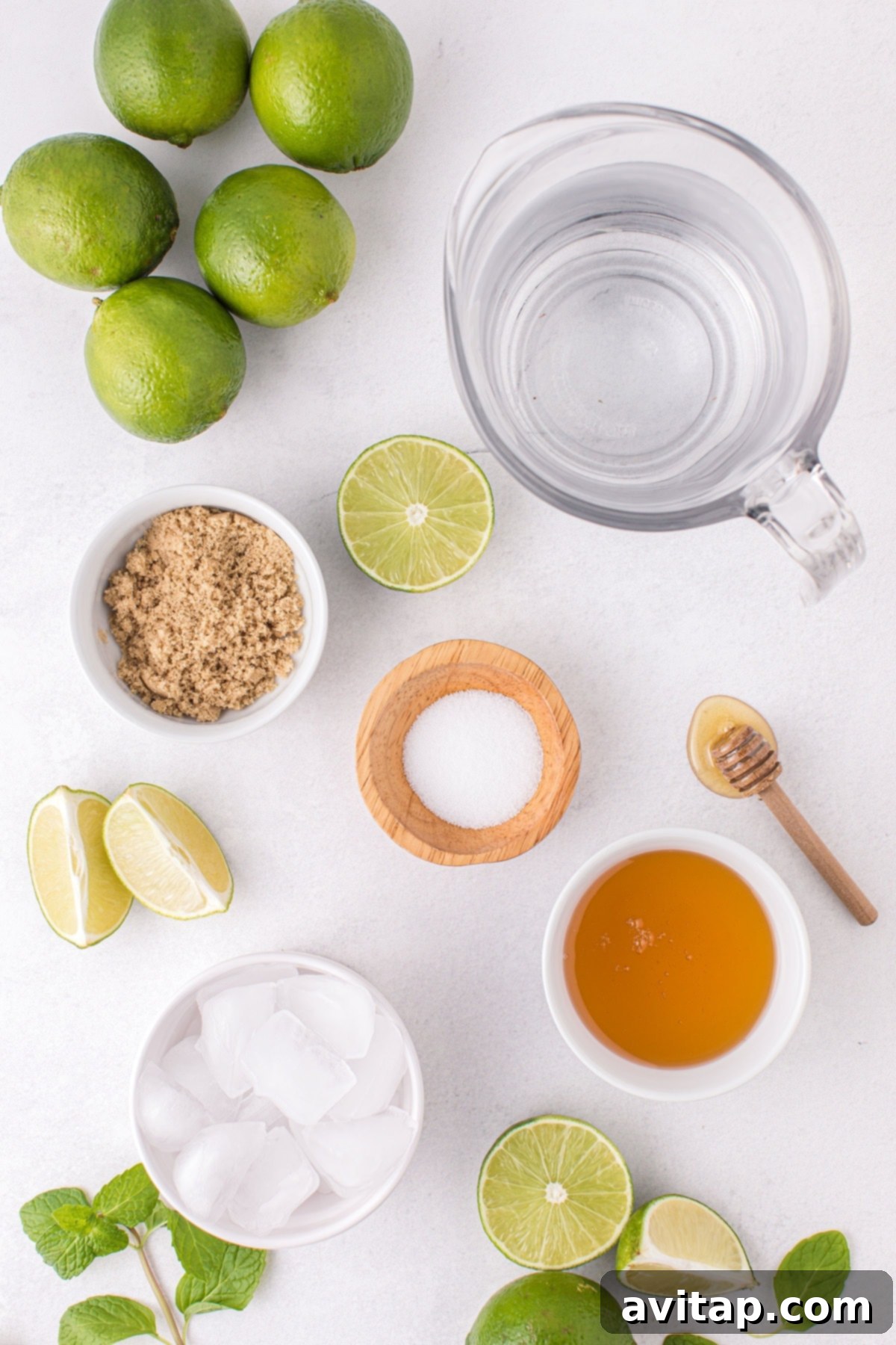 All the limeade recipe ingredients, including fresh limes, honey, brown sugar, and water, meticulously laid out on a clean counter, ready to be combined for the delicious drink.