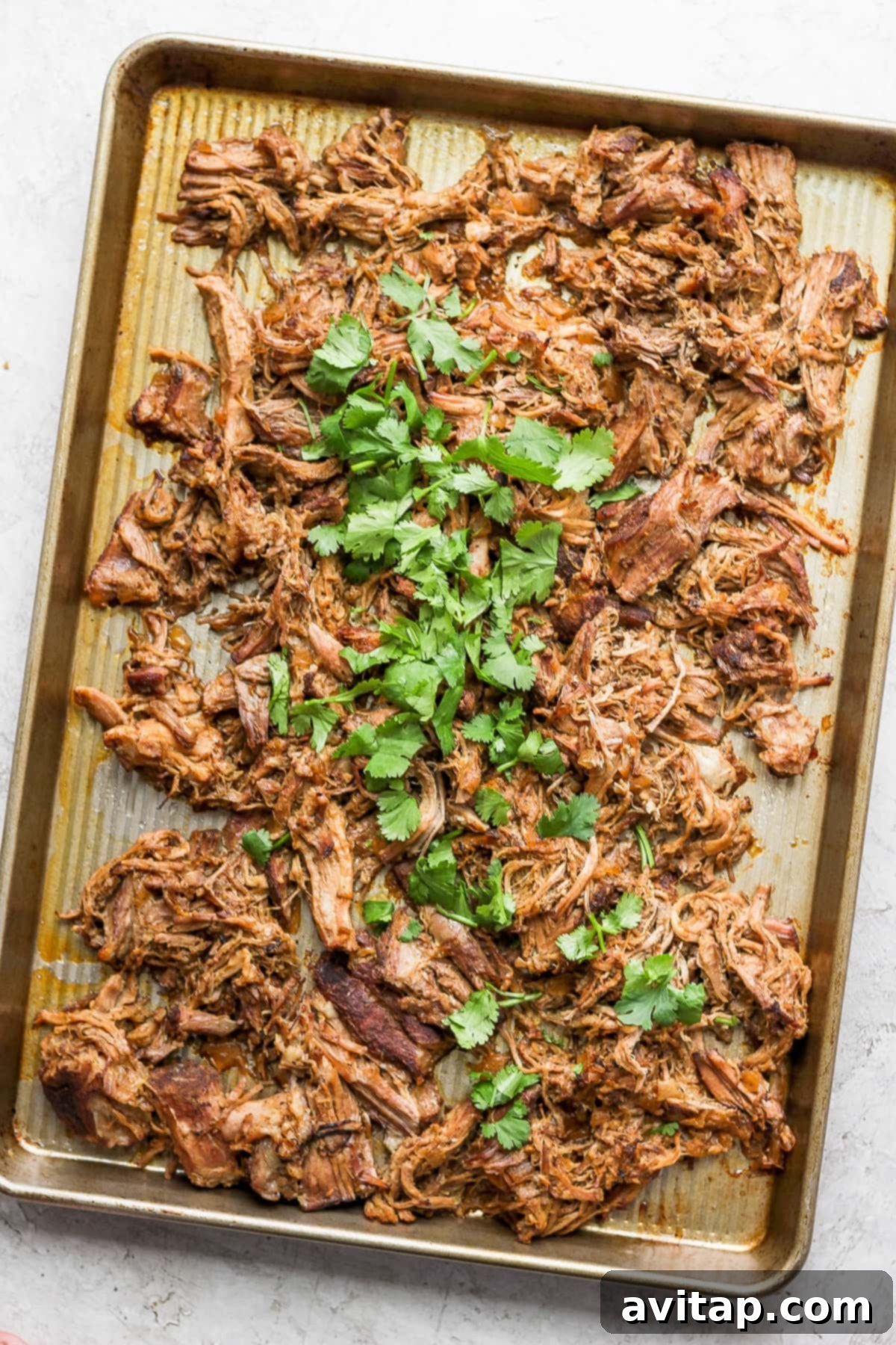 Crispy, shredded carnitas on a baking sheet, ready to be served.