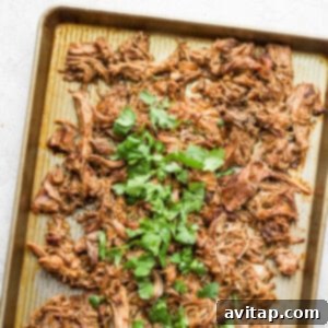 Slow Cooker Carnitas on a baking sheet, ready to be served in a taco.