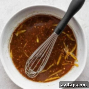 a bowl of chili sauce with a whisk in it.