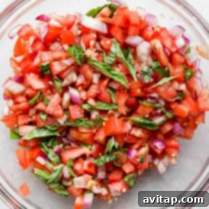 a glass bowl filled with chopped up vegetables.