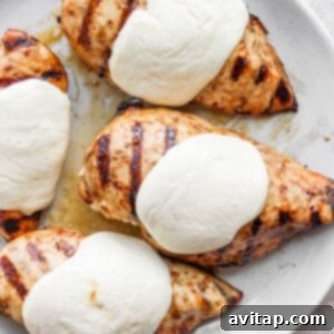 a white plate topped with chicken breasts covered in ice cream.