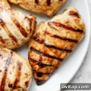grilled chicken breasts on a white plate.