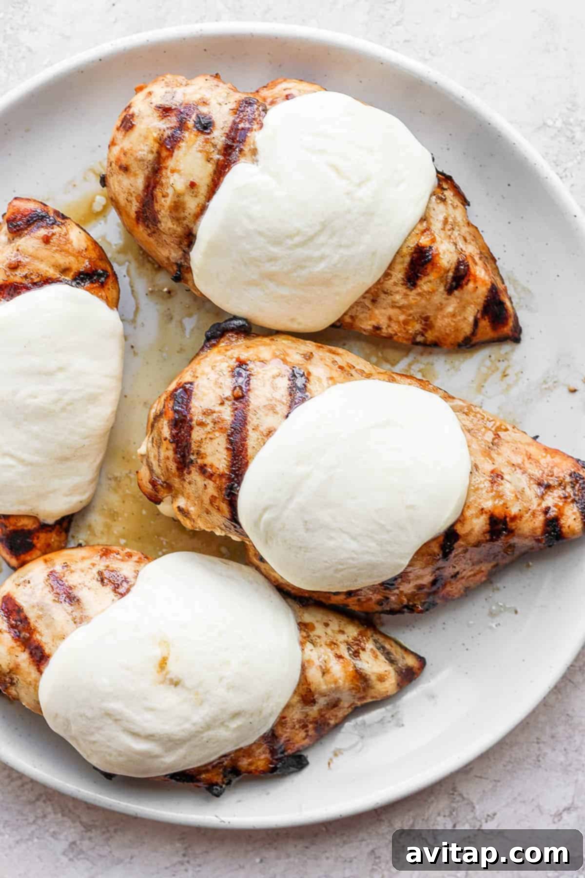Melted mozzarella perfectly covering a grilled chicken breast.