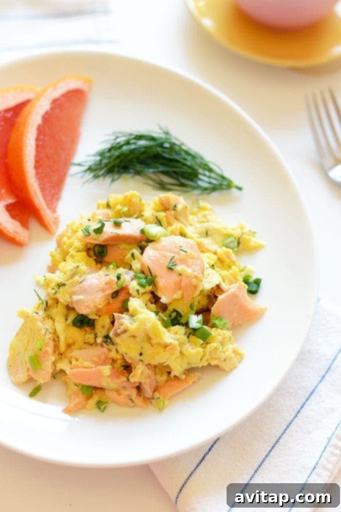 Dill Salmon Scramble with Greek Yogurt Topping A serving of dill salmon and eggs scramble, topped with a creamy sauce.