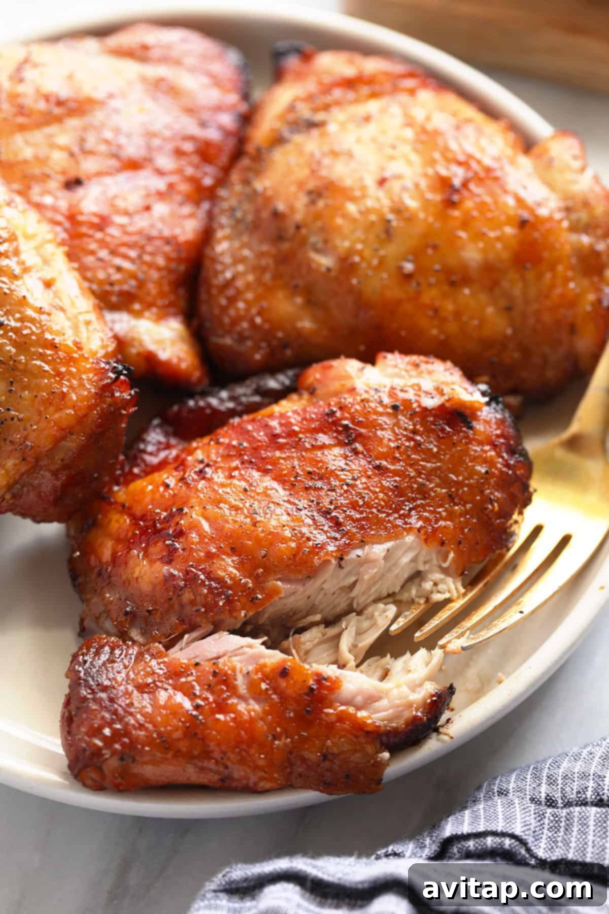 Juicy Smoked Chicken Thighs 2 Perfectly smoked chicken thighs with golden, crispy skin resting on a plate, ready to be served.